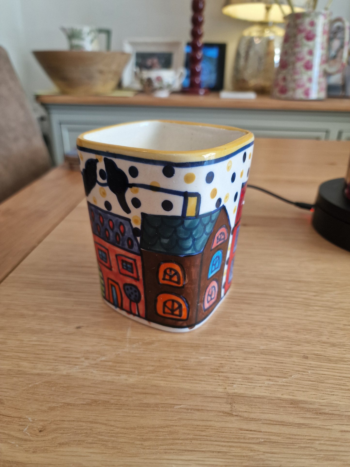 Pair of Colourful Whimsical Village Ceramic Pots H4.5" in colourful hand-painted ceramic with village houses and polka dot border on a wooden table in Kitchen & Dining