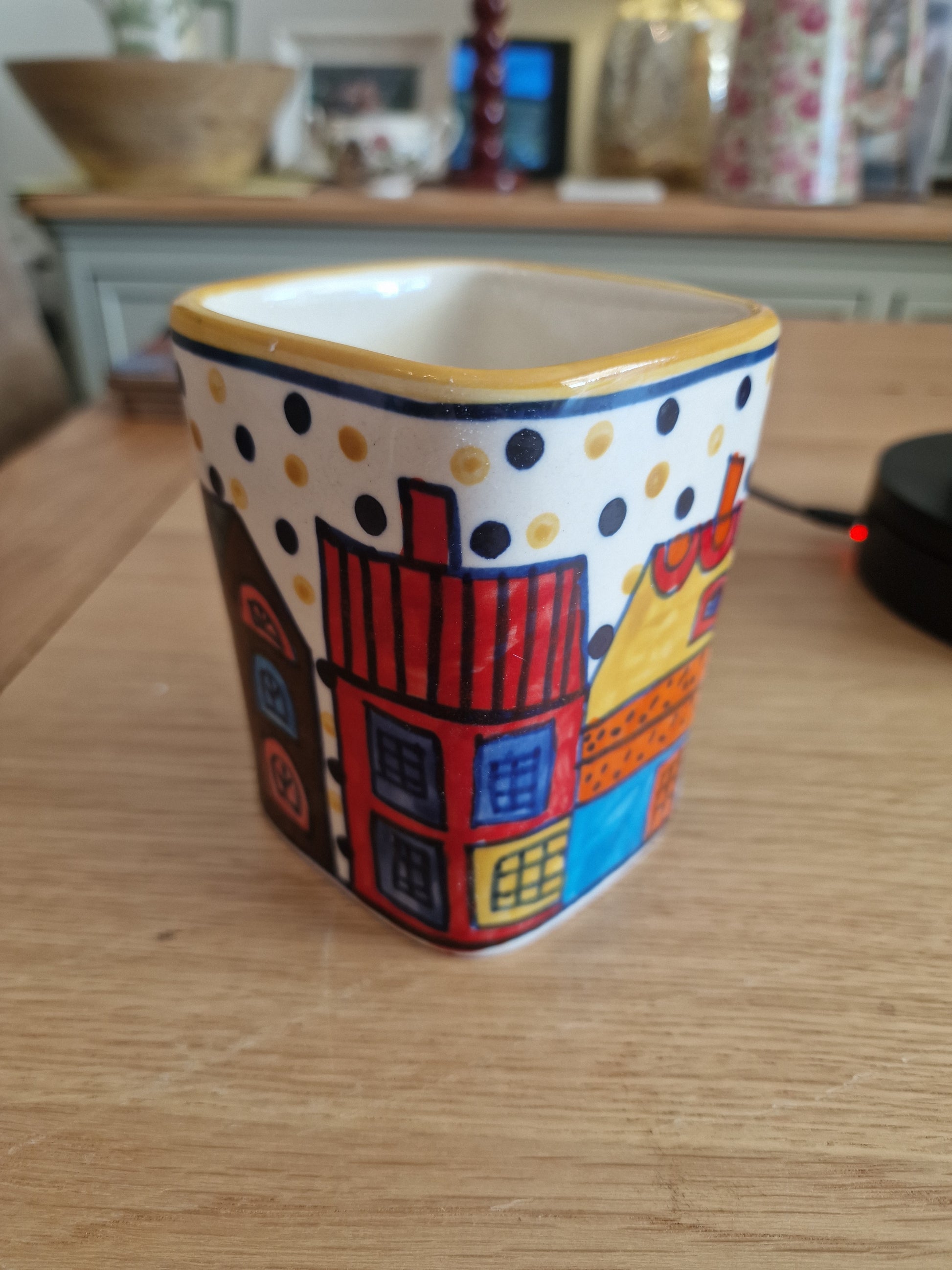 Pair of Colourful Whimsical Village Ceramic Pots H4.5" in hand-painted ceramic with colourful village houses and polka dot border on a wooden table in Kitchen & Dining